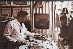 Boy looking through the store window at seafood