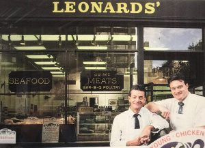 Two men standing outside meat and seafood market